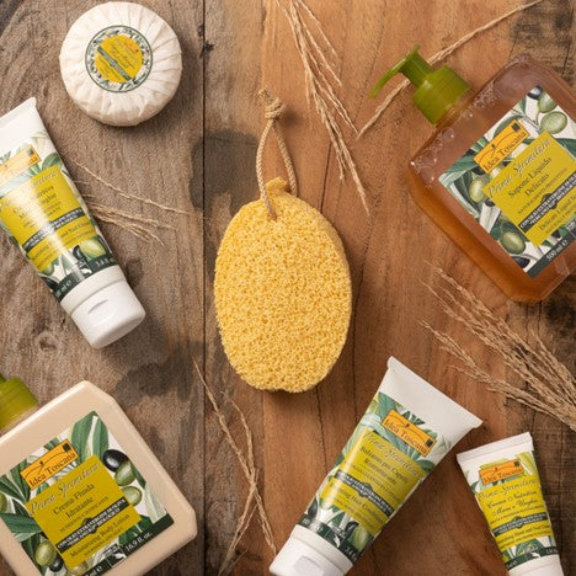 Collection of natural skincare products on a wooden surface with a yellow sponge.