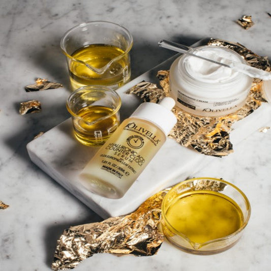 Olivella skincare products with olive oil on a marble surface