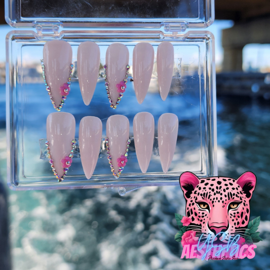 A set of press-on nails in a white French manicure style with gemstone accents, displayed in a clear case. White Frenchies Gems Luxurious Press On Nails made by YSB Aesthetics LLC.